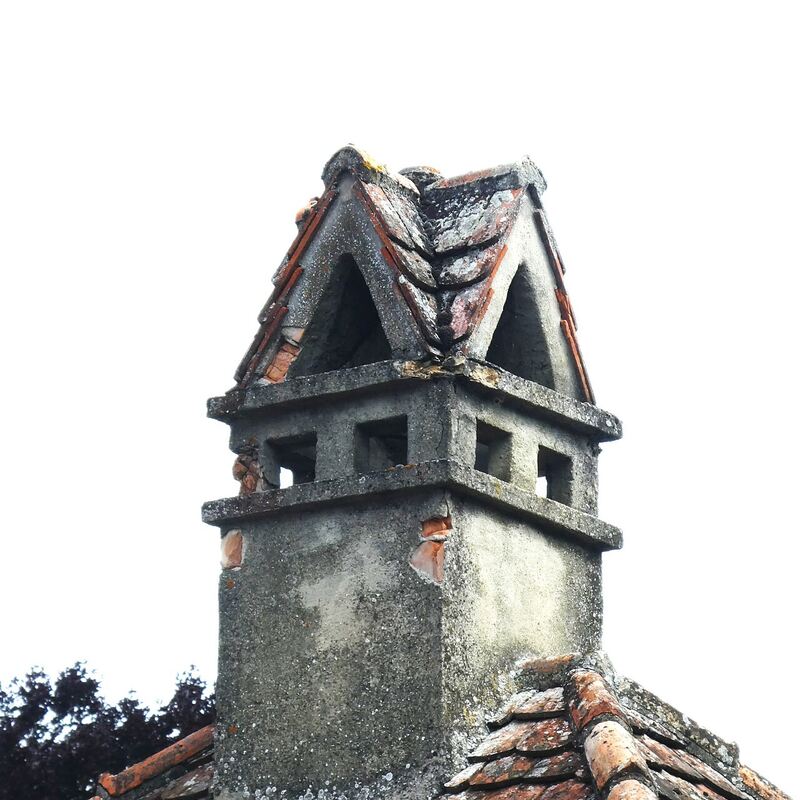 Tête de cheminée ancienne en brique et pierre